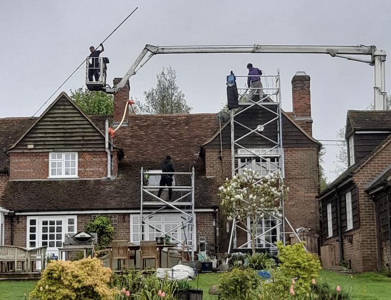 The Roof Moss Cleaners using cherry picker and scaffolding to clean roof safely and professionally in Storrington, West Sussex